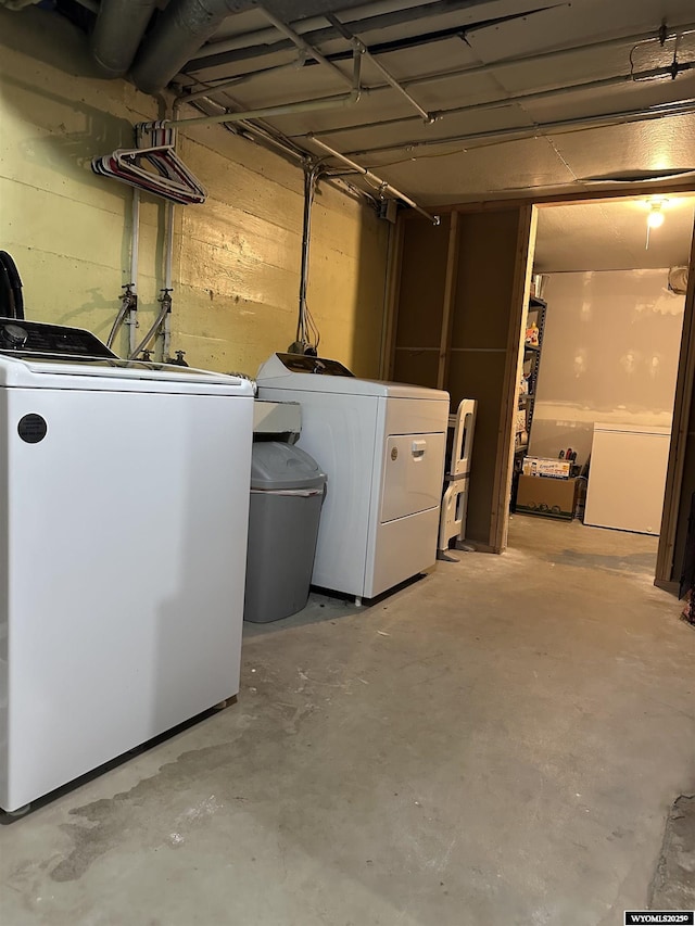 unfinished basement with washer and dryer and fridge