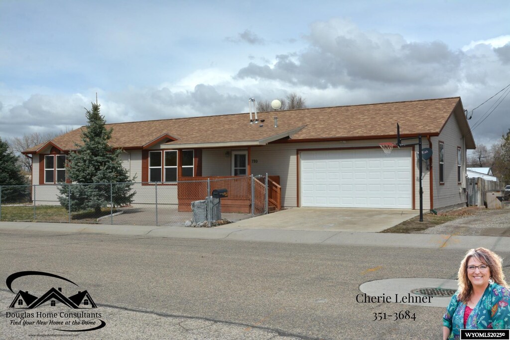 ranch-style house featuring a garage, a shingled roof, fence, and concrete driveway