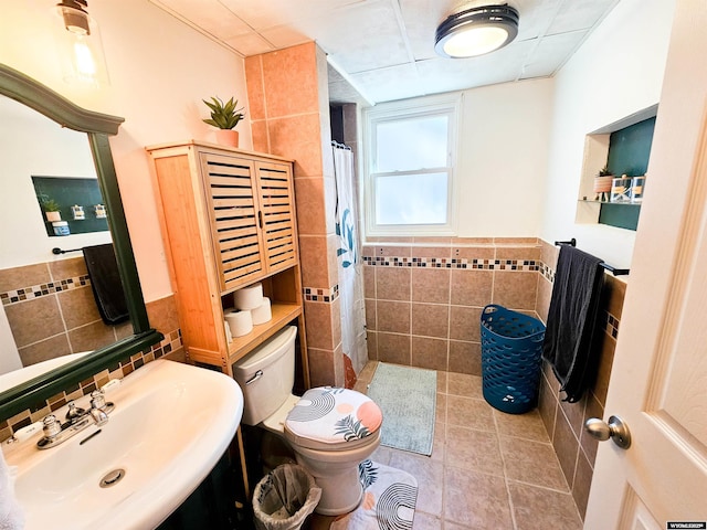 3617 Bighorn St, Torrington, WY 82240 - full bathroom with tiled shower, tile patterned flooring, toilet, a sink, and tile walls