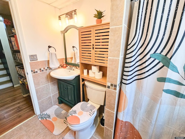 3617 Bighorn St, Torrington, WY 82240 - full bathroom with toilet, tile walls, vanity, wainscoting, and tile patterned floors