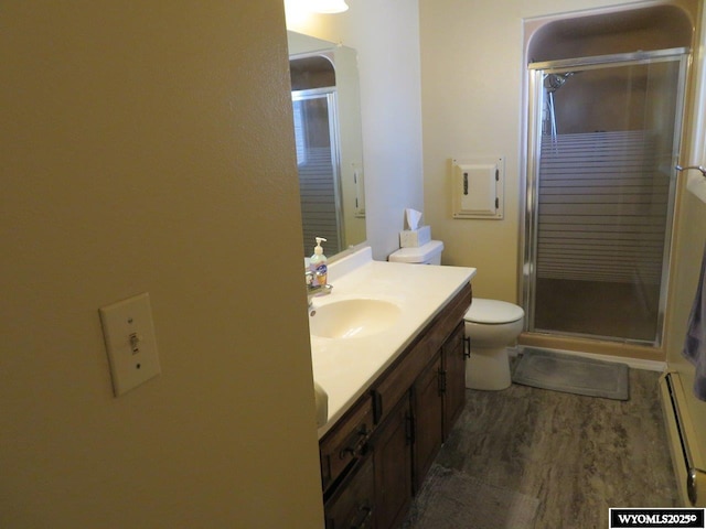 1001 Cheshire St, Casper, WY 82609 - bathroom featuring vanity, toilet, wood finished floors, a baseboard heating unit, and a stall shower
