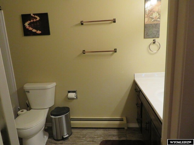 1001 Cheshire St, Casper, WY 82609 - bathroom with vanity, baseboards, toilet, a baseboard radiator, and wood finished floors