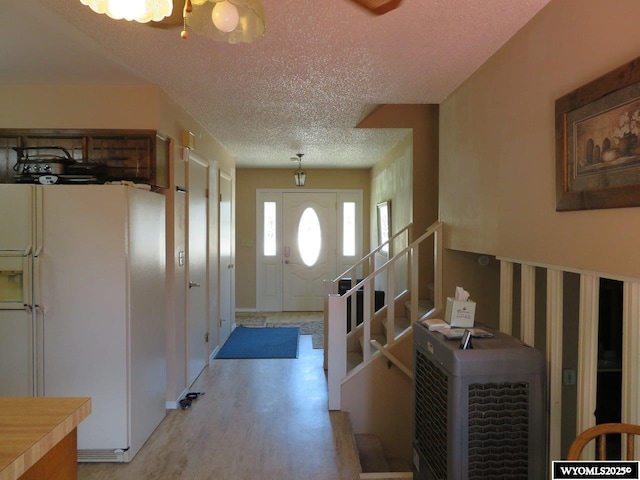 1001 Cheshire St, Casper, WY 82609 - entrance foyer with stairway, a notable chandelier, wood finished floors, and a textured ceiling