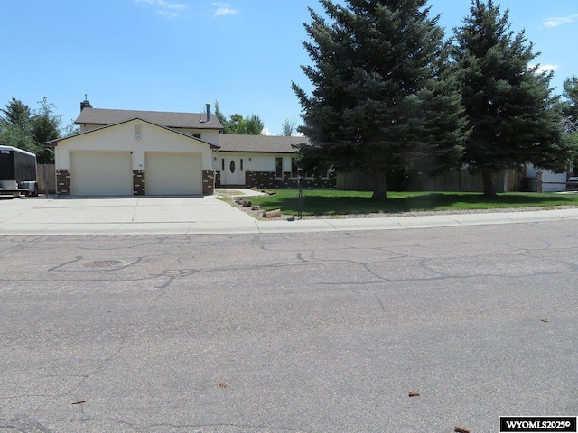 1001 Cheshire St, Casper, WY 82609 - view of front facade with an attached garage, concrete driveway, and a front lawn