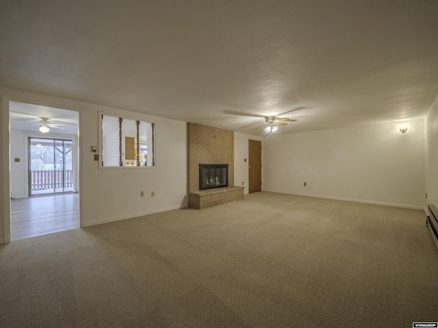 unfurnished living room with baseboards, a fireplace, light colored carpet, and a ceiling fan