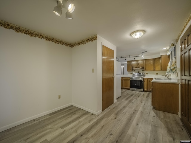 kitchen featuring a sink, light countertops, light wood-type flooring, brown cabinets, and stainless steel range with electric cooktop