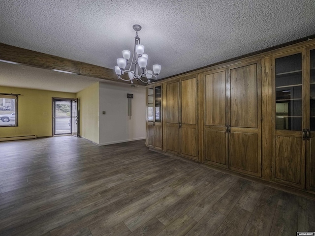 unfurnished dining area with dark wood-style flooring, a chandelier, a textured ceiling, baseboard heating, and beamed ceiling