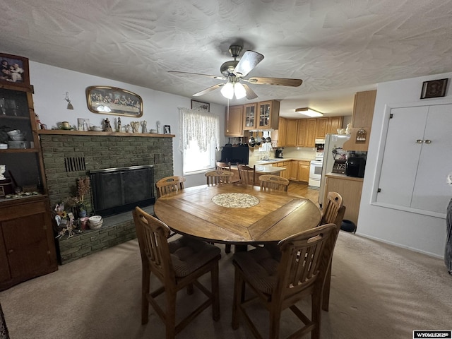 341 E 29th Ave, Torrington, WY 82240 - dining room featuring light carpet, a fireplace, a ceiling fan, and a textured ceiling