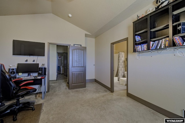 office area featuring light carpet, baseboards, and vaulted ceiling