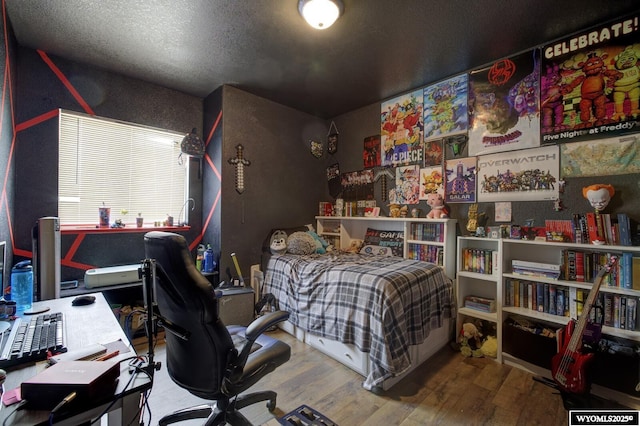 bedroom with a textured ceiling and wood finished floors