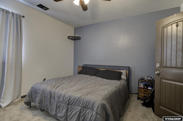 carpeted bedroom with visible vents and a ceiling fan
