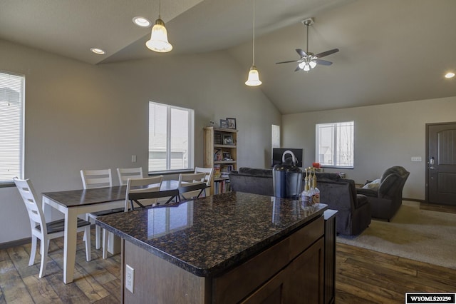 kitchen featuring open floor plan, a ceiling fan, dark wood-style floors, and hanging light fixtures