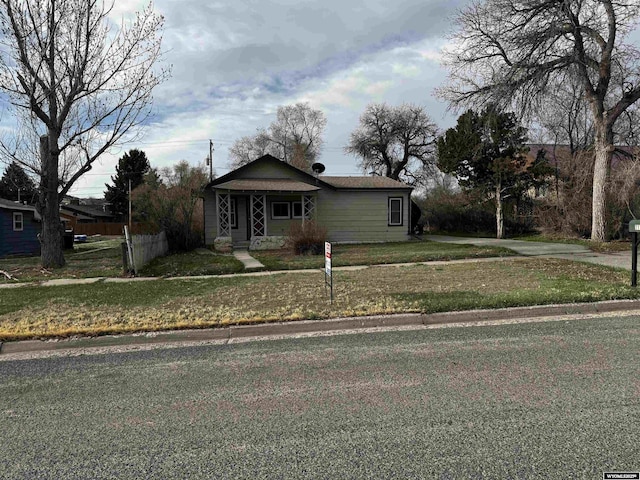 bungalow featuring fence and a front yard