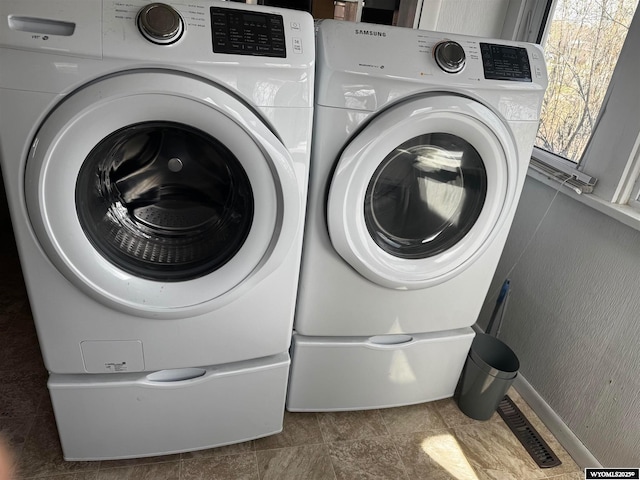 laundry area with washing machine and clothes dryer and laundry area