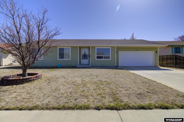ranch-style home featuring an attached garage, driveway, and fence