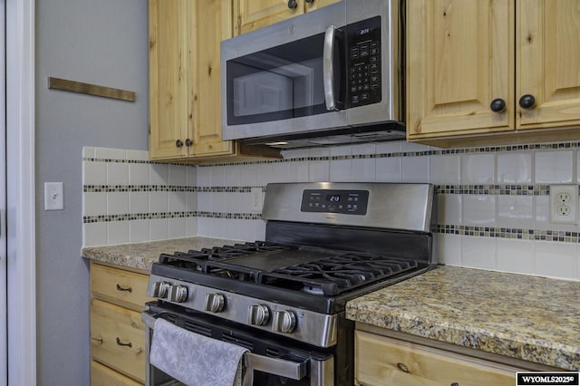 kitchen with tasteful backsplash, light stone counters, light brown cabinetry, and stainless steel appliances