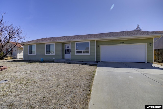 ranch-style home with concrete driveway, fence, and an attached garage