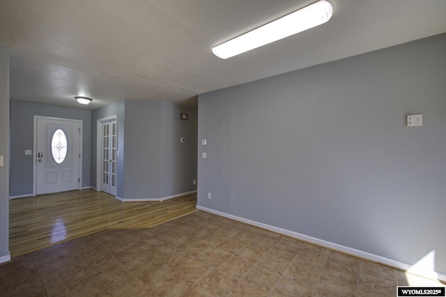 foyer entrance with wood finished floors and baseboards