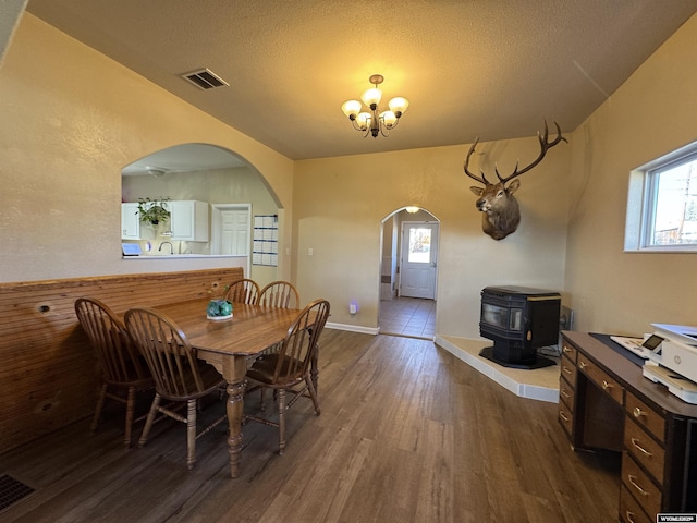 410 E Monroe Ave, Riverton, WY 82501 - dining area with dark wood-style flooring, a notable chandelier, visible vents, and a wood stove