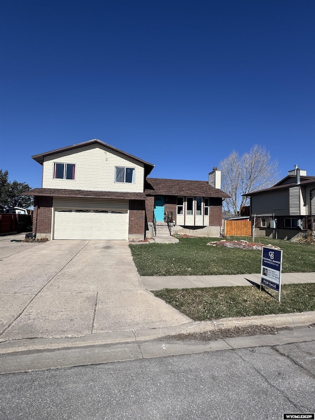 325 Hathaway Ave, Evanston, WY 82930 - tri-level home with a garage, fence, a front lawn, brick siding, and driveway