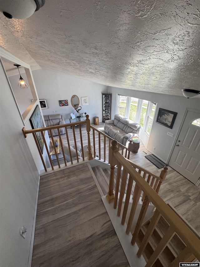325 Hathaway Ave, Evanston, WY 82930 - staircase featuring baseboards, vaulted ceiling, wood finished floors, and a textured ceiling