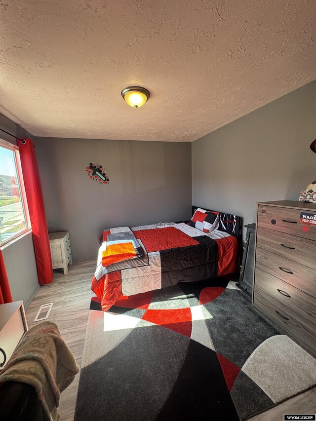 325 Hathaway Ave, Evanston, WY 82930 - bedroom with visible vents, light wood-type flooring, and a textured ceiling