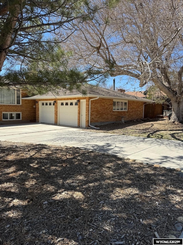 view of home's exterior featuring driveway, a garage, and brick siding
