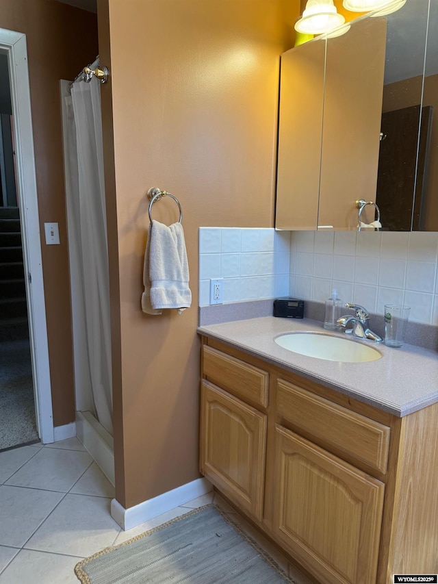 bathroom with tile patterned flooring, decorative backsplash, a shower stall, and vanity