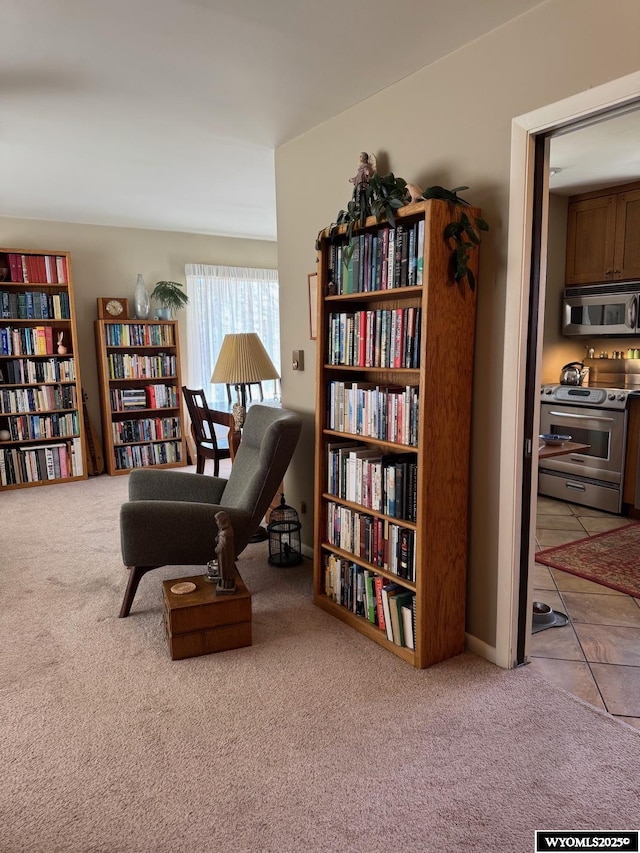 living area with bookshelves and carpet floors