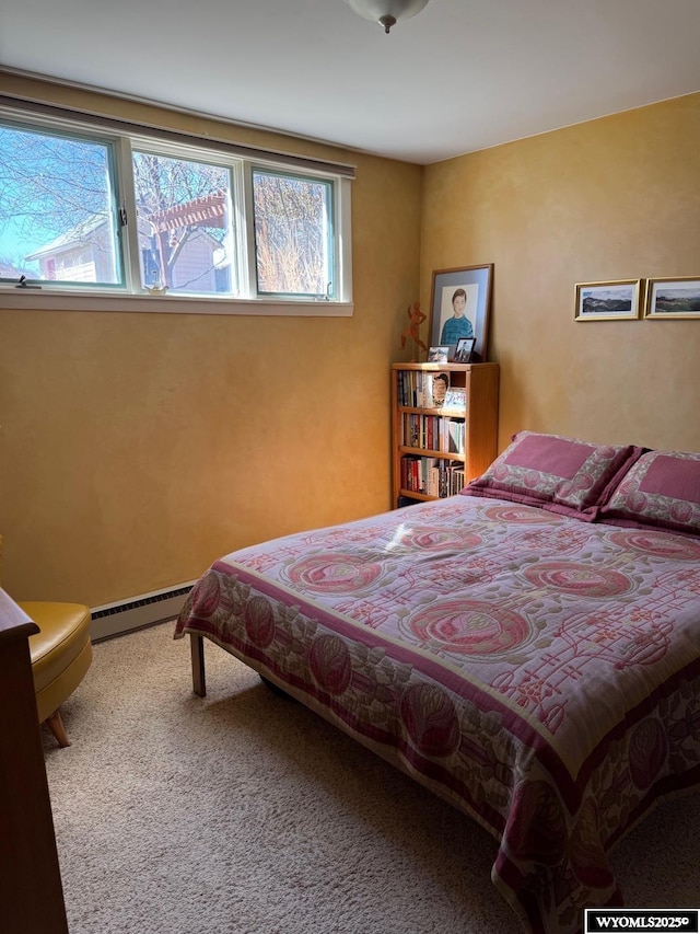 bedroom featuring carpet, multiple windows, and a baseboard heating unit