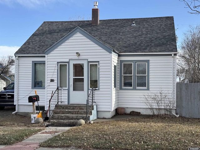 117 W Madison, Riverton, WY 82501 - bungalow-style home featuring entry steps, a chimney, fence, and a shingled roof