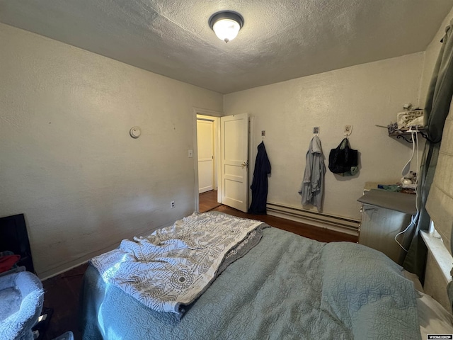 117 W Madison, Riverton, WY 82501 - bedroom featuring a baseboard radiator, wood finished floors, and a textured ceiling