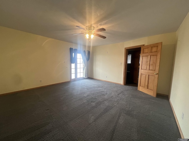 unfurnished room featuring dark carpet, baseboards, and a ceiling fan