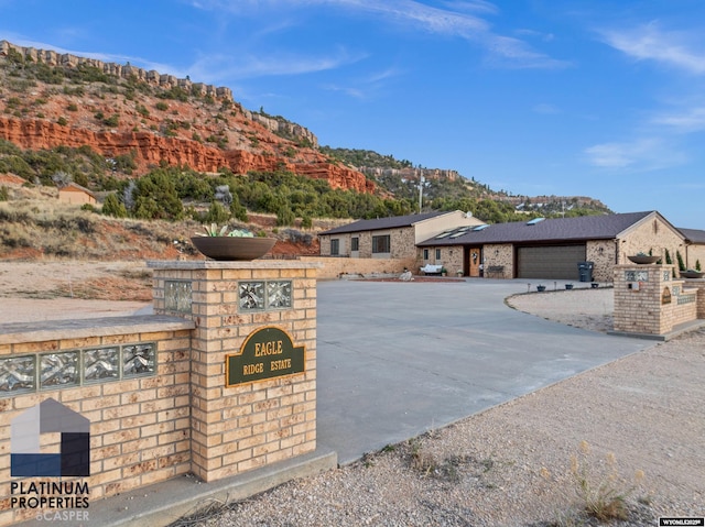 view of front facade with a mountain view, driveway, and a garage