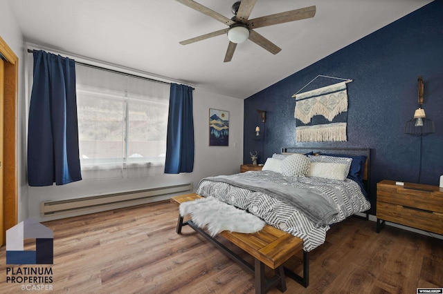 bedroom featuring ceiling fan, a baseboard radiator, vaulted ceiling, and wood finished floors