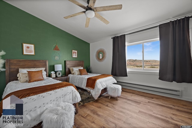 bedroom featuring baseboard heating, wood finished floors, ceiling fan, and lofted ceiling