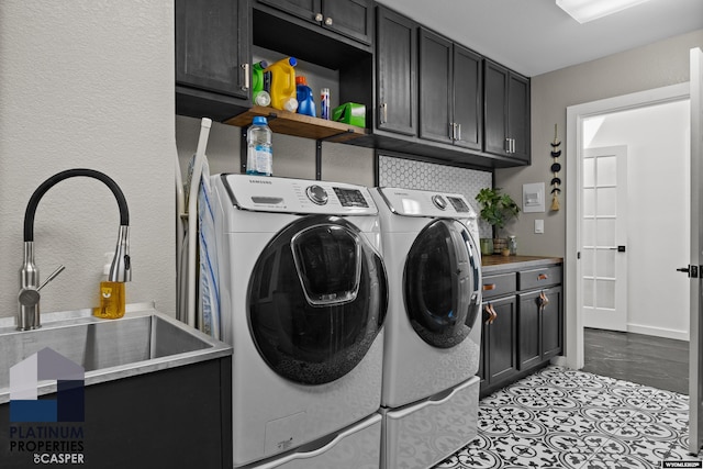 clothes washing area featuring washer and dryer, a sink, and cabinet space