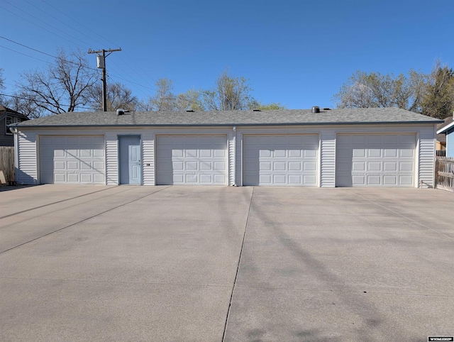 detached garage featuring fence