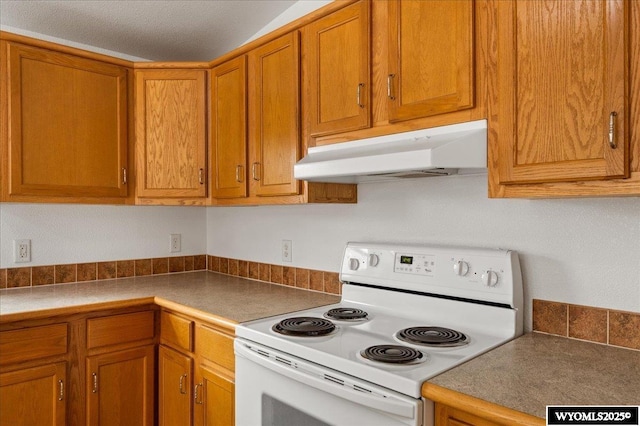 kitchen featuring brown cabinets, under cabinet range hood, and white electric range