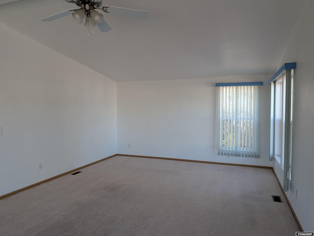 carpeted spare room featuring ceiling fan, baseboards, and visible vents