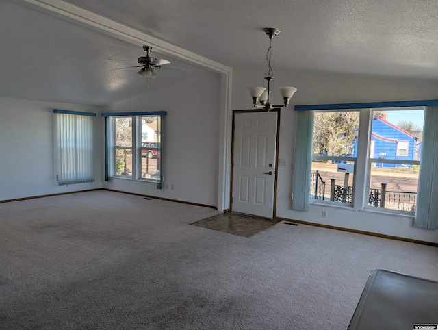 interior space featuring baseboards, ceiling fan with notable chandelier, and lofted ceiling