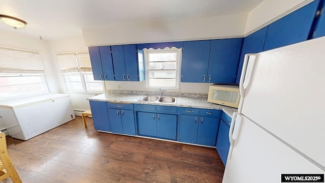 kitchen featuring blue cabinets, a wealth of natural light, white appliances, and a sink
