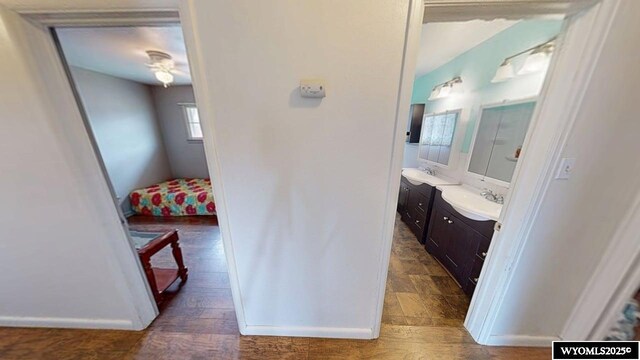 bathroom with baseboards, wood finished floors, vanity, and ensuite bathroom