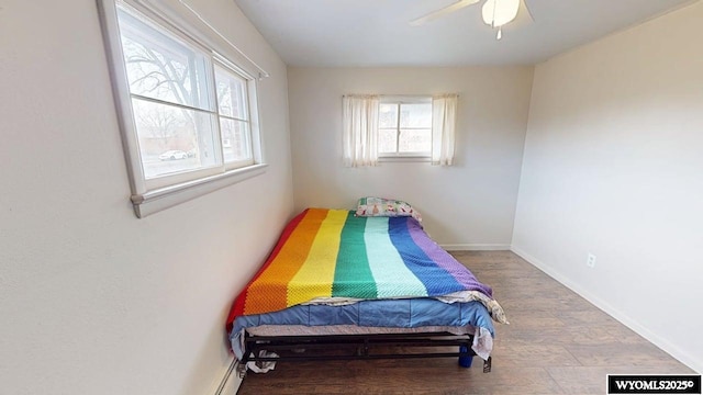 bedroom with wood finished floors, baseboards, and ceiling fan