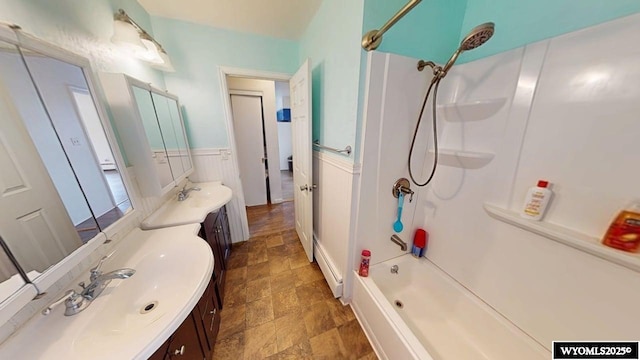 bathroom with vanity, stone finish floor, and shower / bathing tub combination