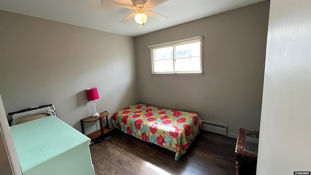 bedroom featuring a baseboard heating unit, a ceiling fan, baseboards, and dark wood finished floors