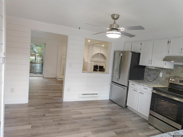 kitchen with light wood finished floors, stainless steel appliances, a ceiling fan, crown molding, and under cabinet range hood