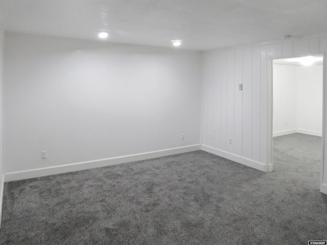 empty room with dark carpet and baseboards