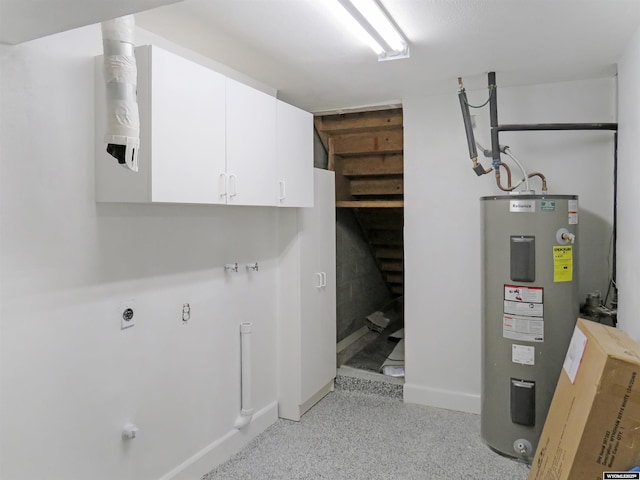 interior space with electric dryer hookup, baseboards, water heater, and cabinet space