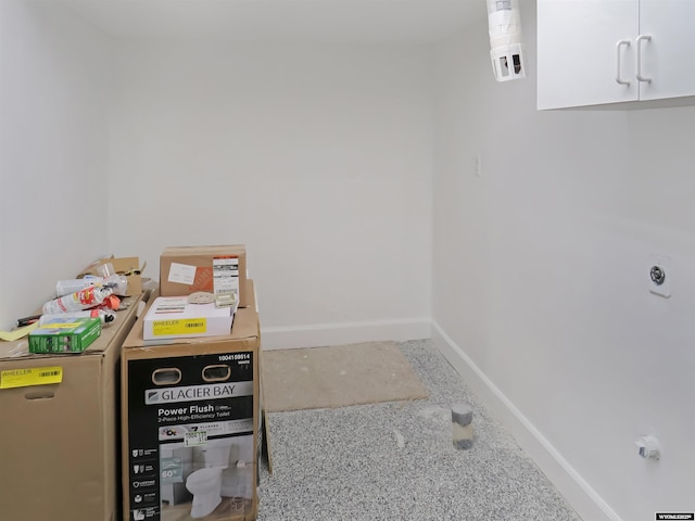 washroom with baseboards and cabinet space
